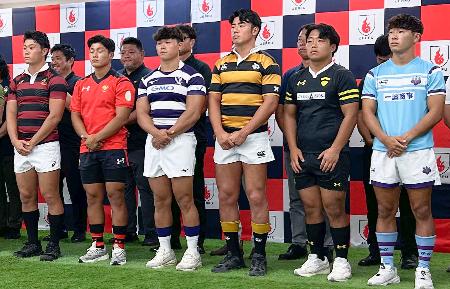 ラグビーの関東大学リーグ開幕に向けた記者会見で、胸にスポンサーのロゴを入れたジャージーを披露した明大の平主将(前列左から3人目)ら=1日、東京都港区