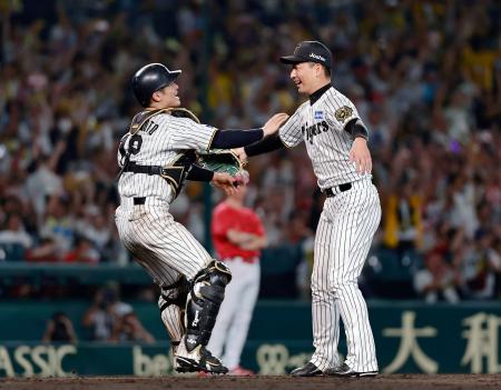 リーグ優勝を決め、抱き合う阪神の岩崎(右)と坂本のバッテリー=甲子園