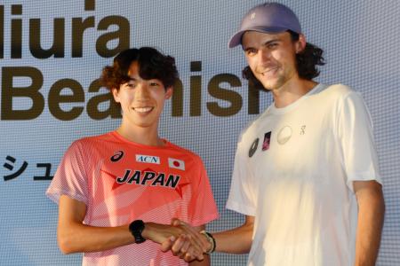 トークイベントに出席し、握手する男子３０００メートル障害の三浦龍司（左）とジョーディ・ビーミッシュ＝１６日、東京都内 