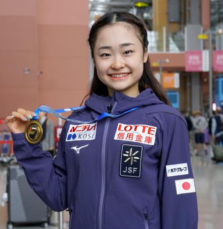 フィギュアスケートのジュニアＧＰシリーズ第７戦を制して帰国し、メダルを手にする島田麻央＝１２日、関西空港 