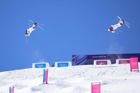 フリースタイルスキー男子デュアルモーグル決勝で第１エアを決める堀島行真（左）＝リビーニョ（共同） 