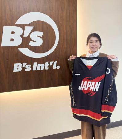 ビーズインターナショナルが製作したパラアイスホッケー日本代表ユニホームを持つ、同社の人事部・広報室マネージャーの岡部千春さん＝２月、東京都目黒区 