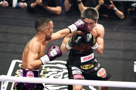 ９回、レネ・サンティアゴ（左）のパンチを浴びる谷口将隆＝後楽園ホール 