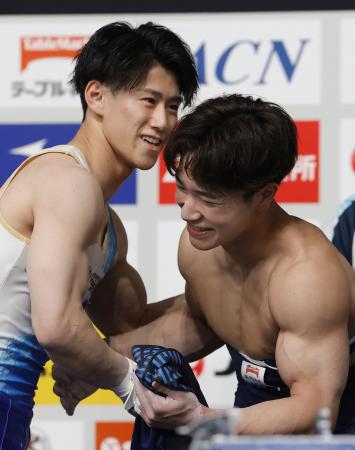 体操ＮＨＫ杯第２日を終え、健闘をたたえ合う橋本大輝（左）と岡慎之助＝東京体育館 