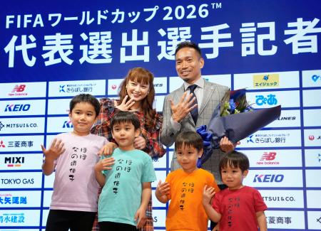 サッカーＷ杯に５大会連続でメンバー入りし、家族と写真に納まるＦＣ東京・長友（右上）＝１７日、東京都内 