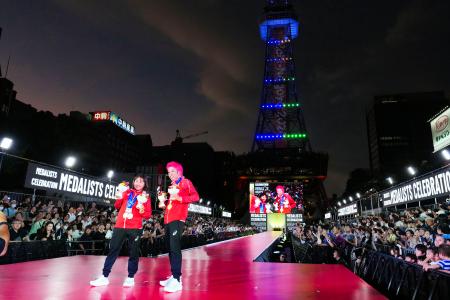 メダリスト祝福イベントでポーズをとる、トライアスロン男子で金の北條巧（右）と女子で銅の林愛望＝２１日夜、名古屋市 